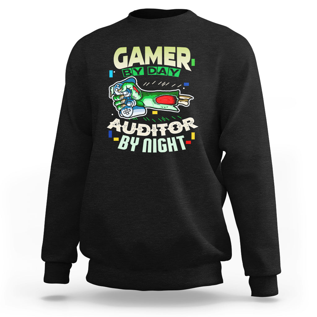 Black crewneck sweatshirt with “GAMER BY DAY” and “AUDITOR BY NIGHT” chest graphic.