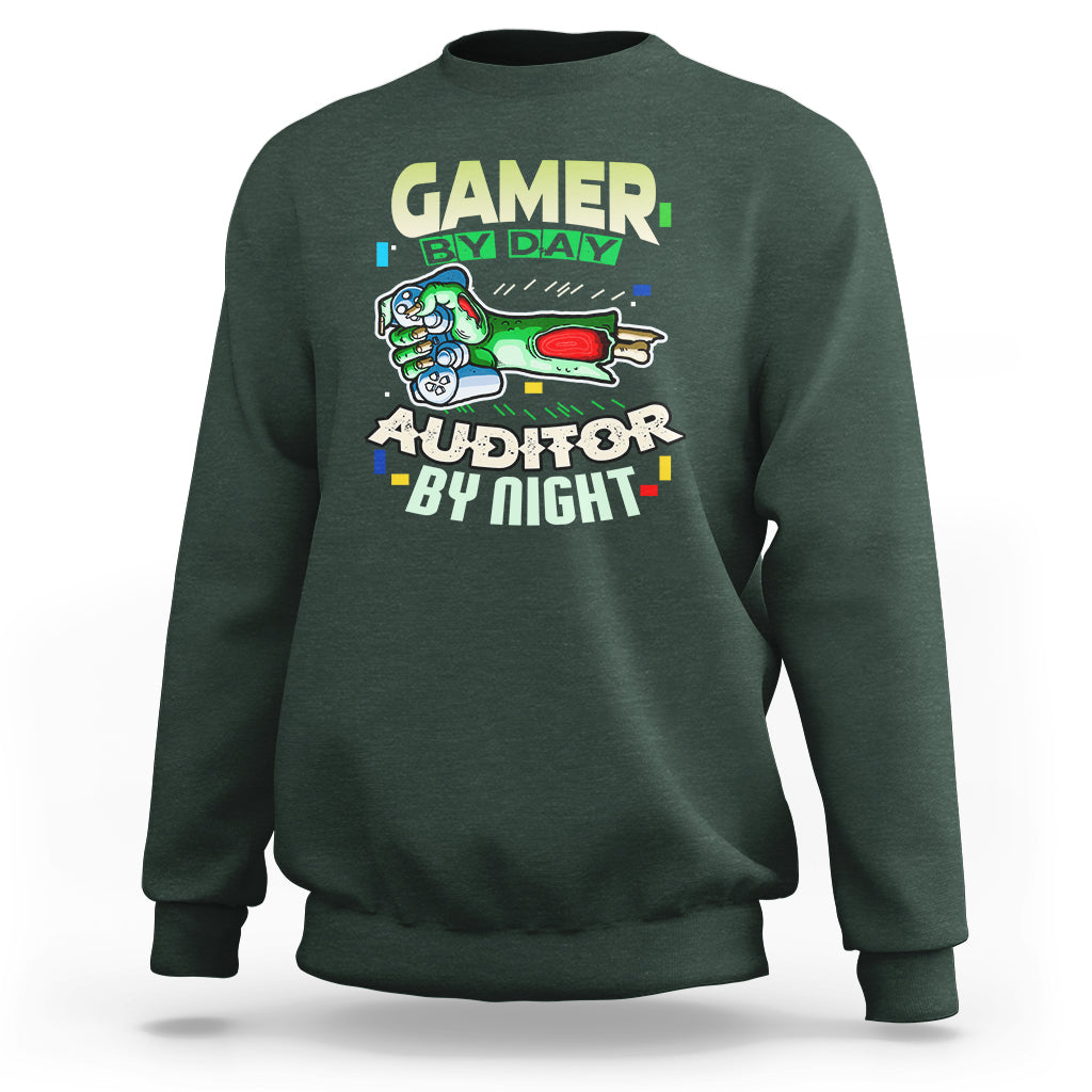 Dark forest green crewneck sweatshirt with “GAMER BY DAY” and “AUDITOR BY NIGHT” chest graphic.