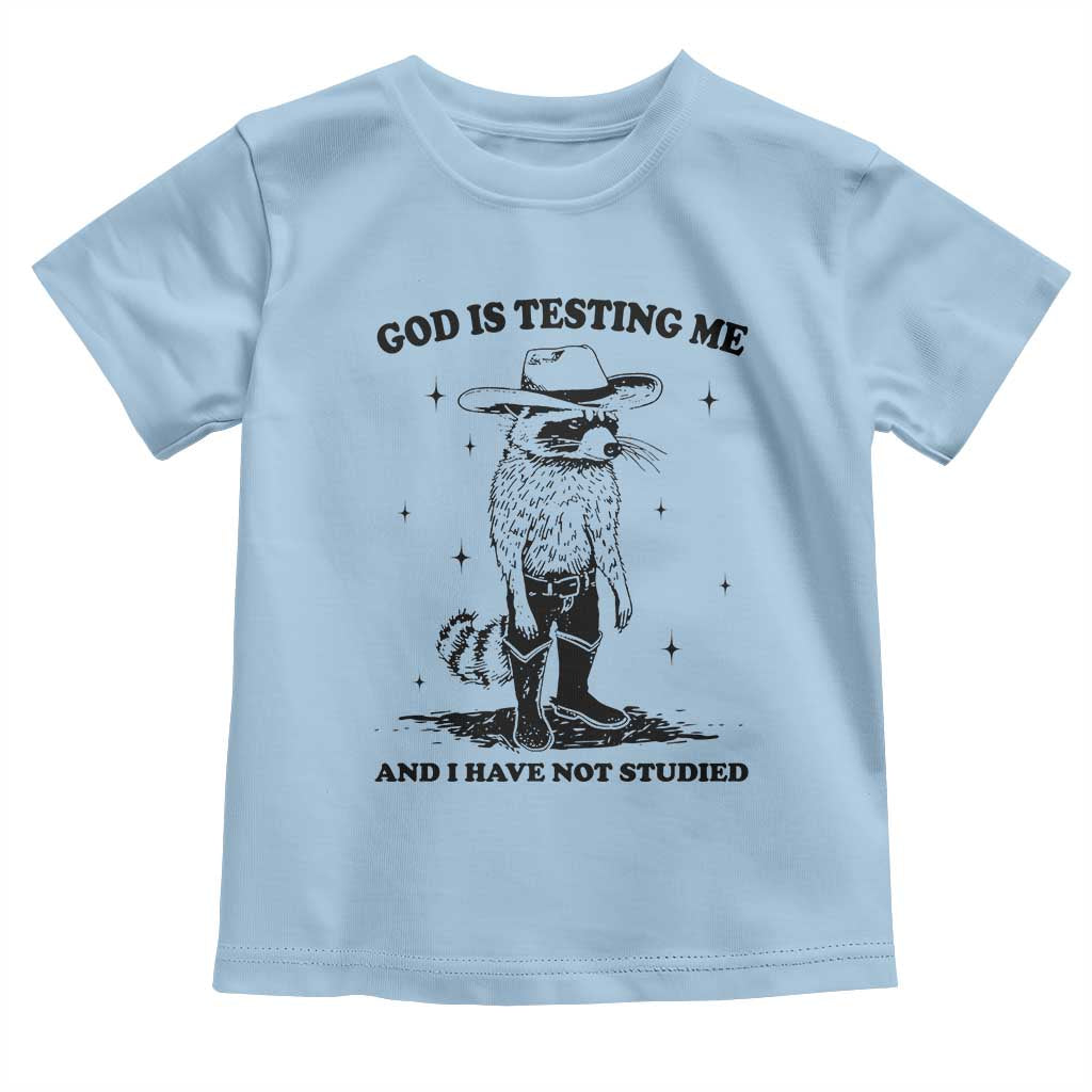 Funny God Is Testing Me And I Have Not Studied Toddler T Shirt Cowboy Racoon