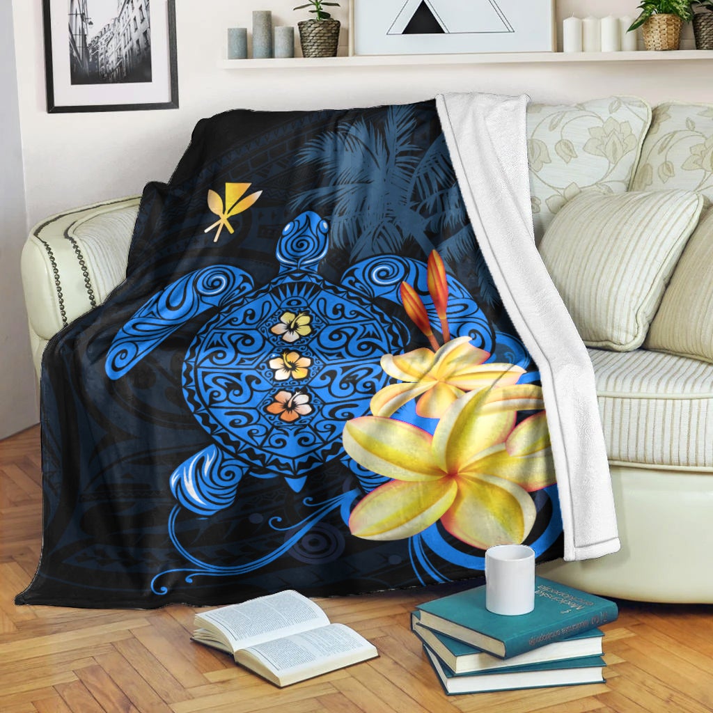 Blue Hawaiian turtle blanket draped on sofa, featuring plumeria and floral mandala