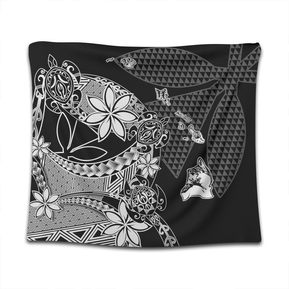 Black Hawaiian tapestry close-up with white ornamental florals, waves, and triangle motifs