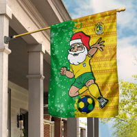 Green-and-yellow football-themed flag with Santa, Brazil crest, and soccer ball on a pole.