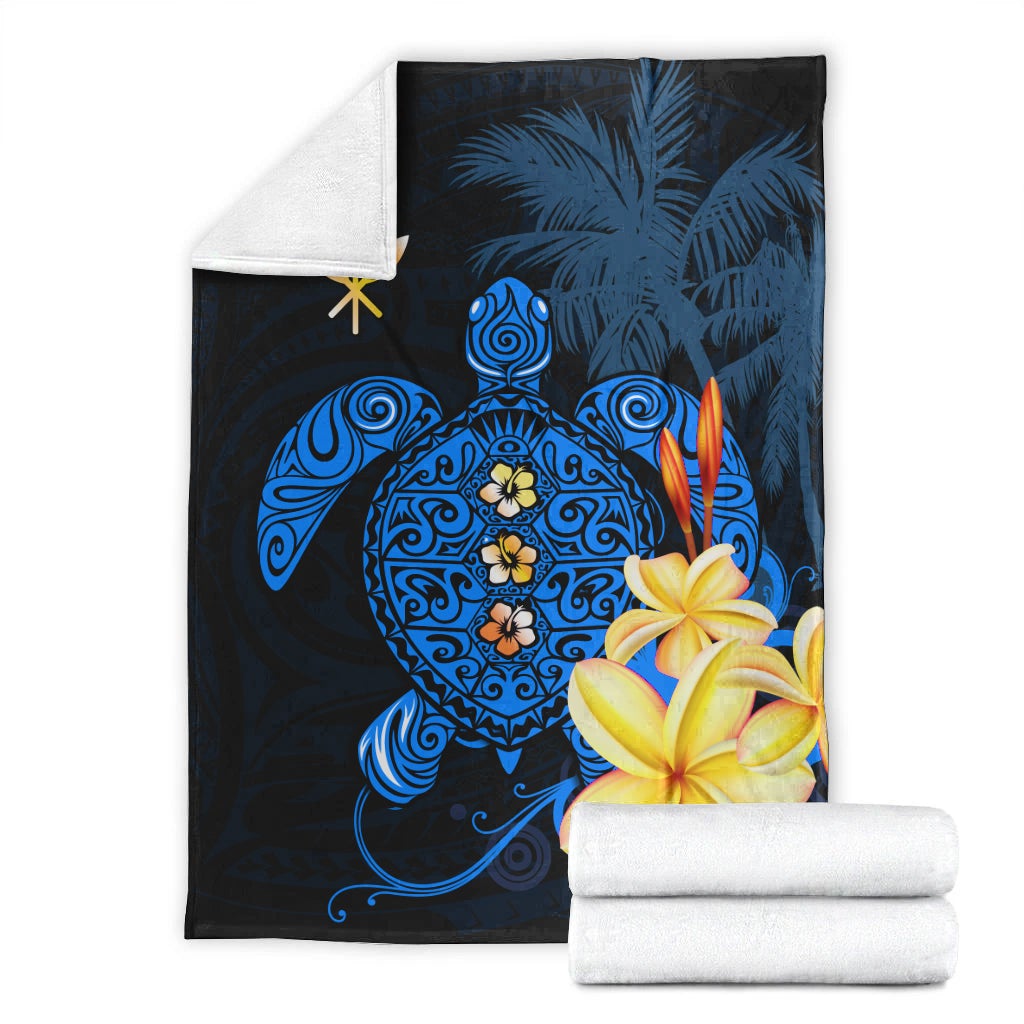 Blue Hawaiian turtle blanket with plumeria flowers; folded with matching white towels