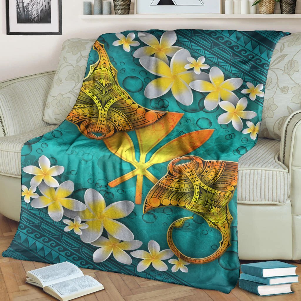 Turquoise Hawaiian blanket with manta ray graphic and scattered white-and-yellow plumeria blooms