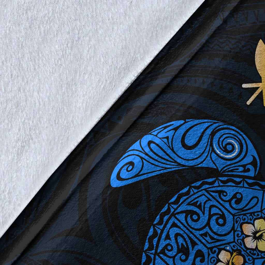 Close-up of blue Hawaiian turtle blanket fabric with plumeria and ornamental patterns