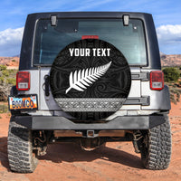 Black circular spare tire cover with white fern and swirl pattern, 'YOUR TEXT' center