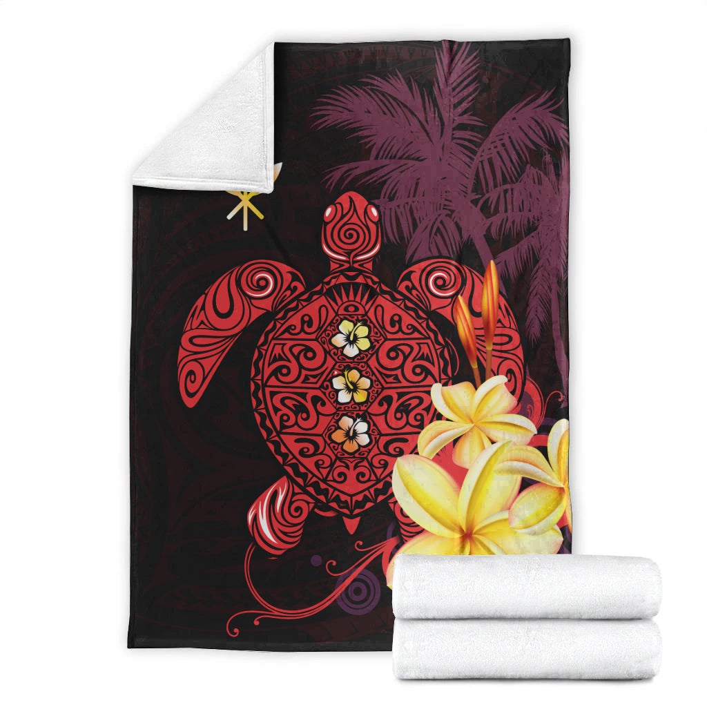 Folded Hawaiian blanket with turtle, palm motifs, and hibiscus flowers in red and yellow