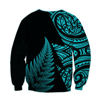 Unisex rugby sweatshirt, black with turquoise fern and tribal pattern on sleeves