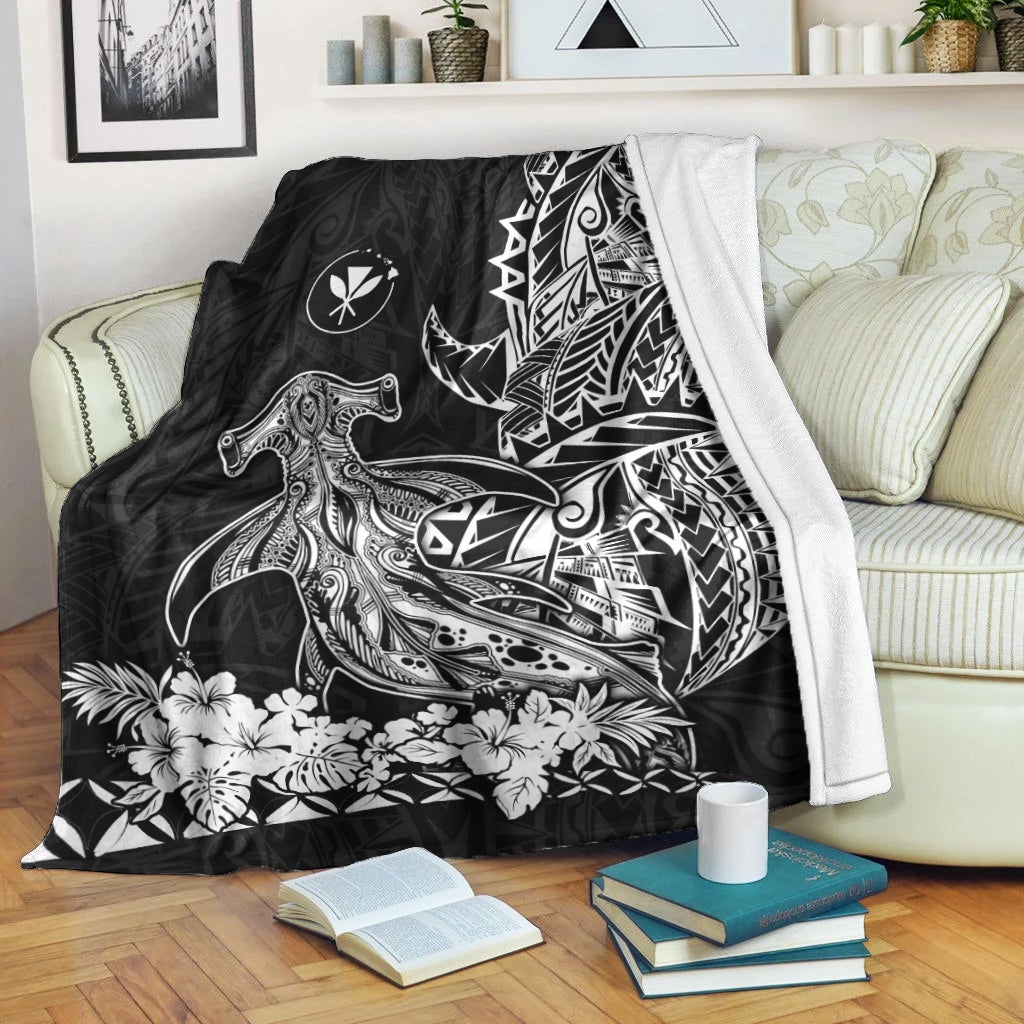Black hammerhead shark blanket with tribal sail motif, draped over armrest