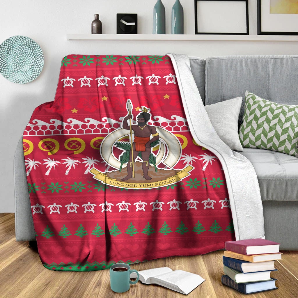 Red Christmas throw blanket with white patterned border, stars, and character emblem in center