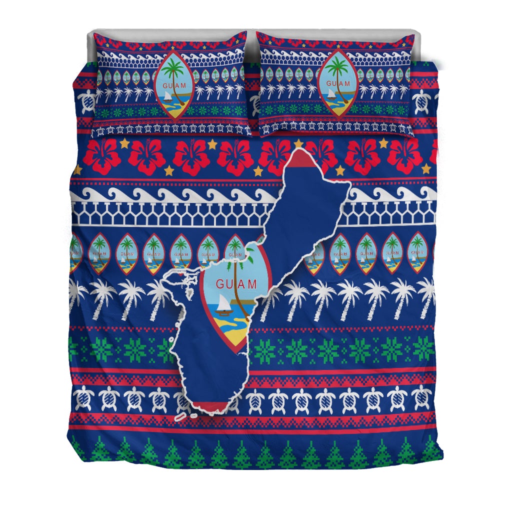 Blue Guam Christmas sheet set with two pillows showing map crest, palms, and red floral motifs