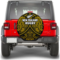 Black circular spare tire cover with gold Maori rugby emblem and silver fern graphic