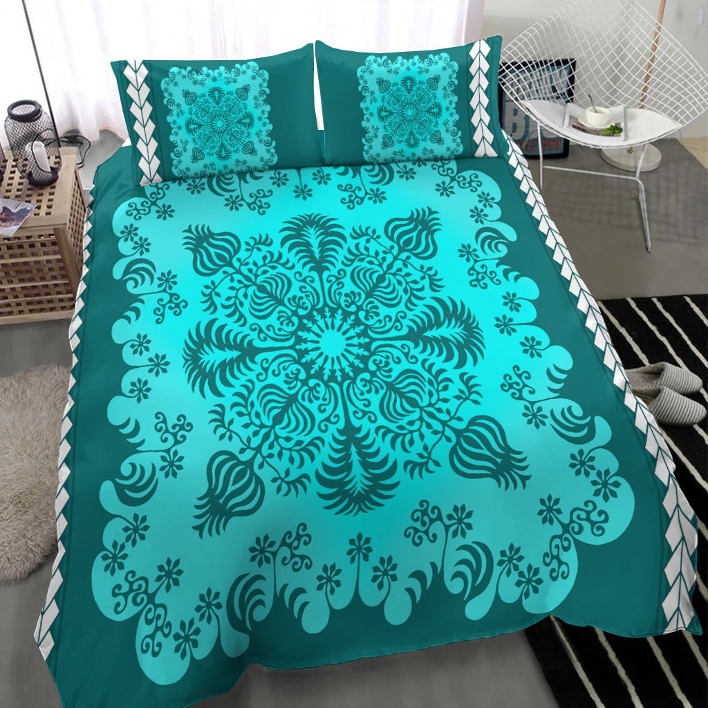 Turquoise and teal comforter with ornate mandala design and two decorative pillows with trim
