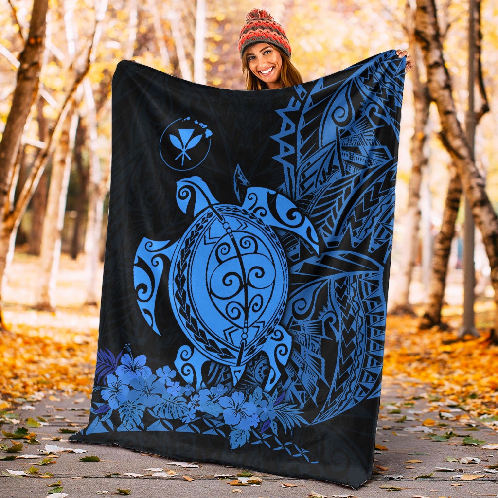 Blue sea turtle design Polynesian blanket laid outdoors on dark fabric with geometric side