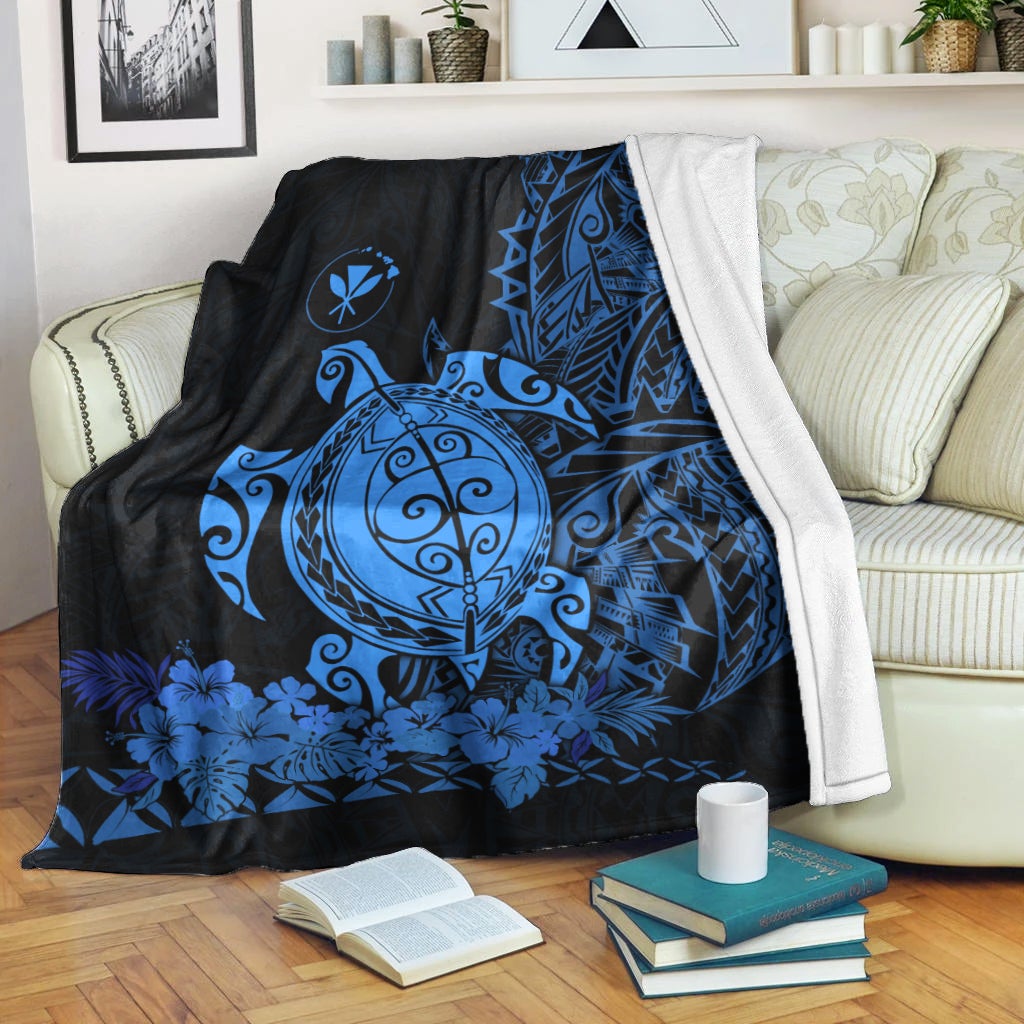 Polyneisan-style blue sea turtle blanket draped over sofa, floral leaf border pattern