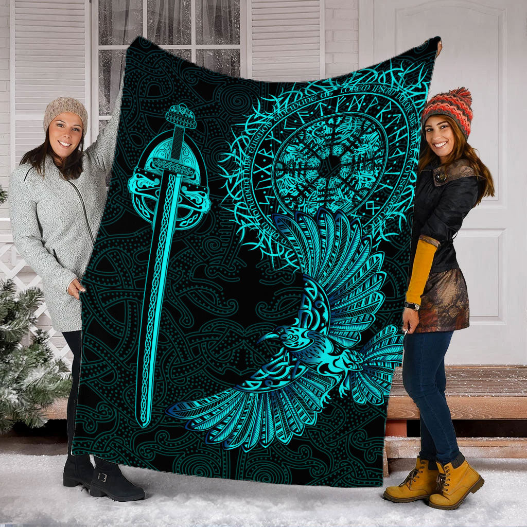 Black blanket with teal Viking raven tattoo design held up, sword and wing graphic