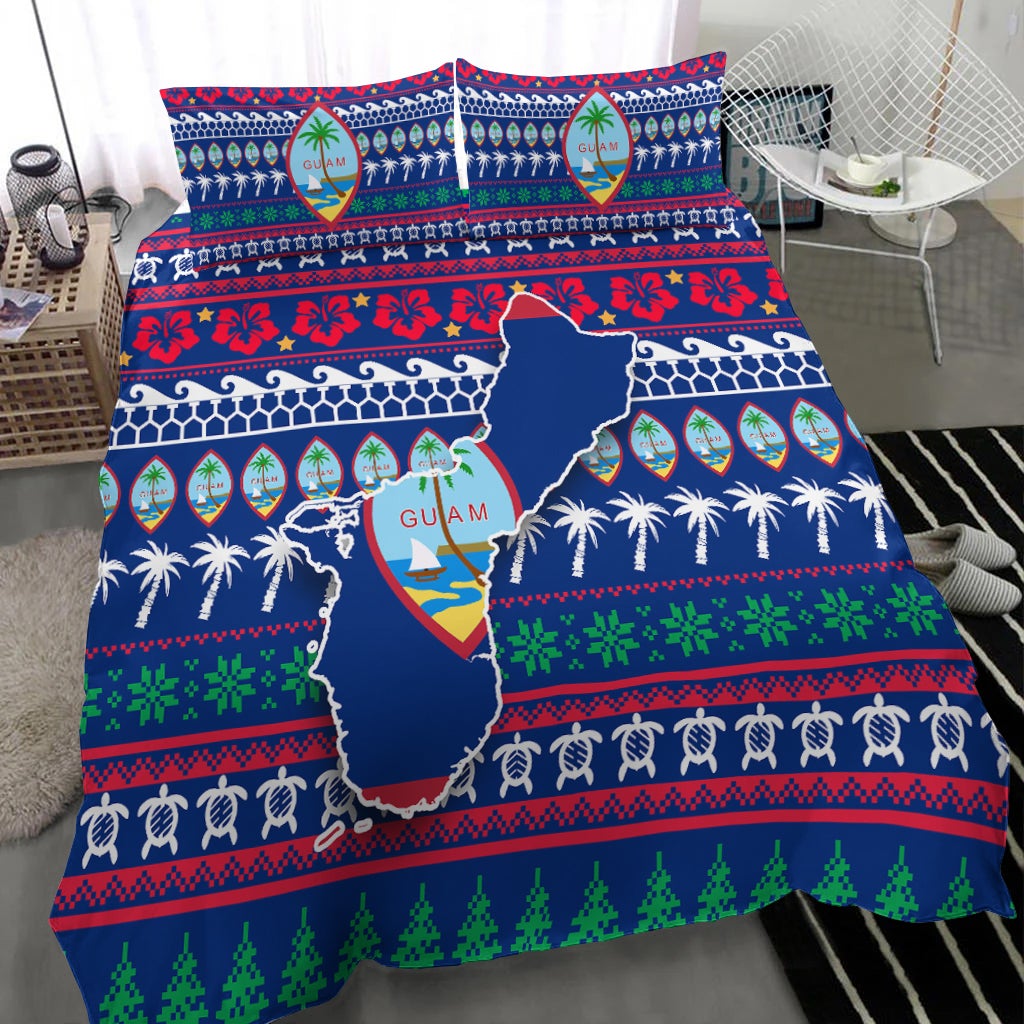 Blue Guam bedding set on bed with map design, palm border, and red/green winter patterns