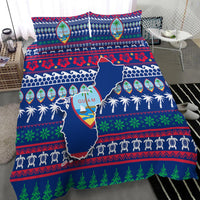Blue Guam bedding set on bed with map design, palm border, and red/green winter patterns