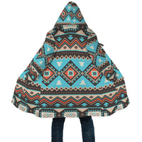 Hooded cloak with multicolor geometric print and wide drape; front pocket detail