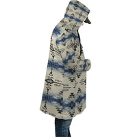 Side view: long hooded cloak with seamless geometric print in blue/black/cream, unisex