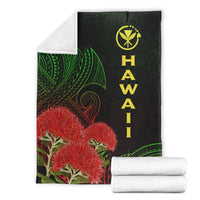 Black Hawaii Polynesian blanket folded with white backing rolls; green patterns and red ohia design
