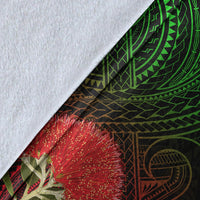 Close-up of black Hawaii Polynesian blanket fabric with green pattern and red ohia blossoms