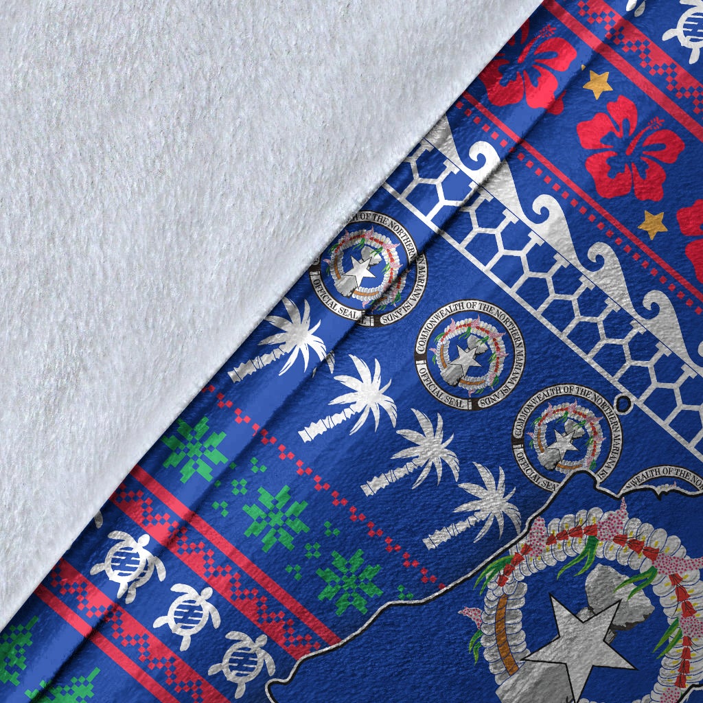Close-up of blue fabric Christmas blanket with North Mariana Islands emblem, palm trees and trim