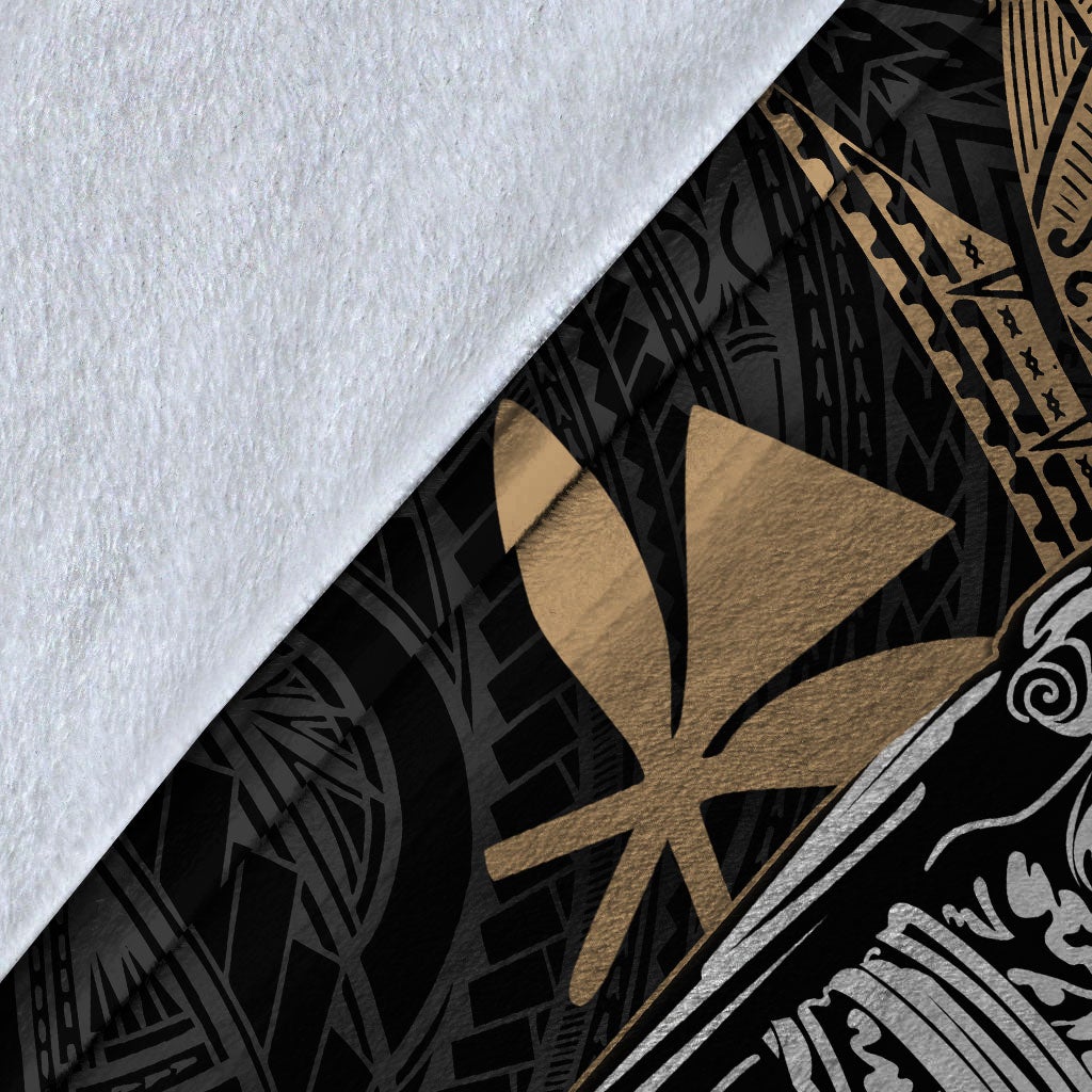 Close-up of black and gold tribal blanket fabric with starburst print and white artwork