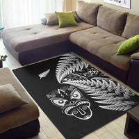 Black rug featuring large white fern fronds and Maori mask motif across center