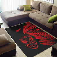 Black rug with red fern feather design and carved tiki face motif