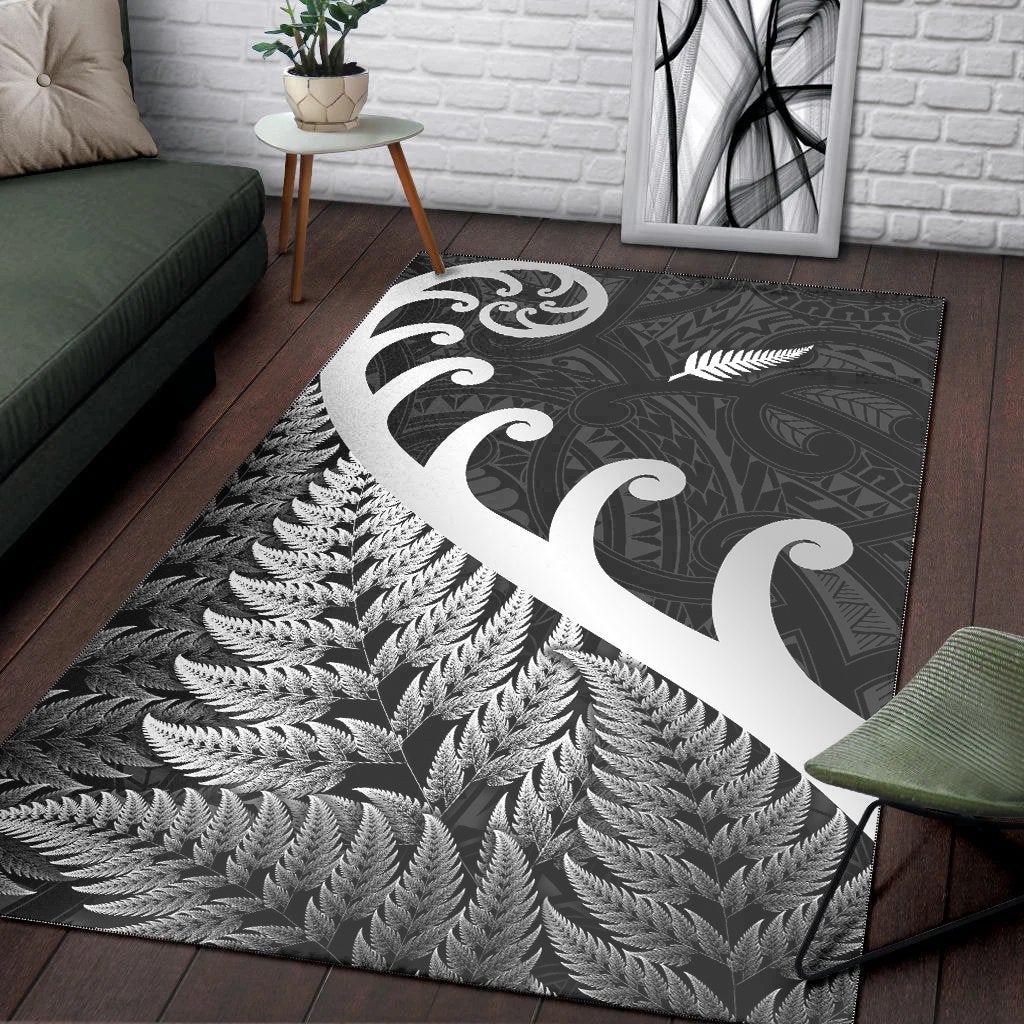 Black rug with large white koru swirl, fern fronds border and patterned center