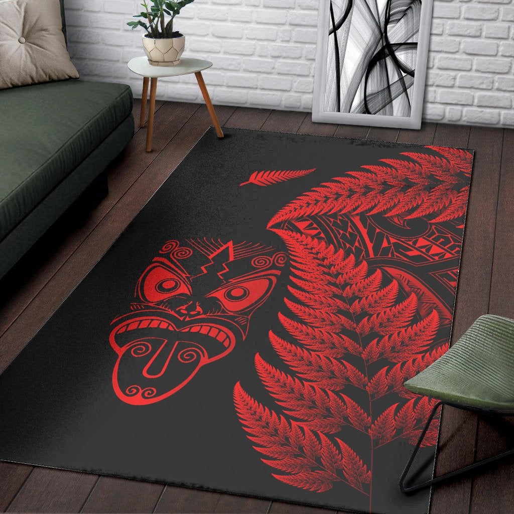 Black rug with red fern foliage and Māori tiki mask graphic