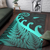 Turquoise koru swirl and fern leaf design on dark green rectangular area rug