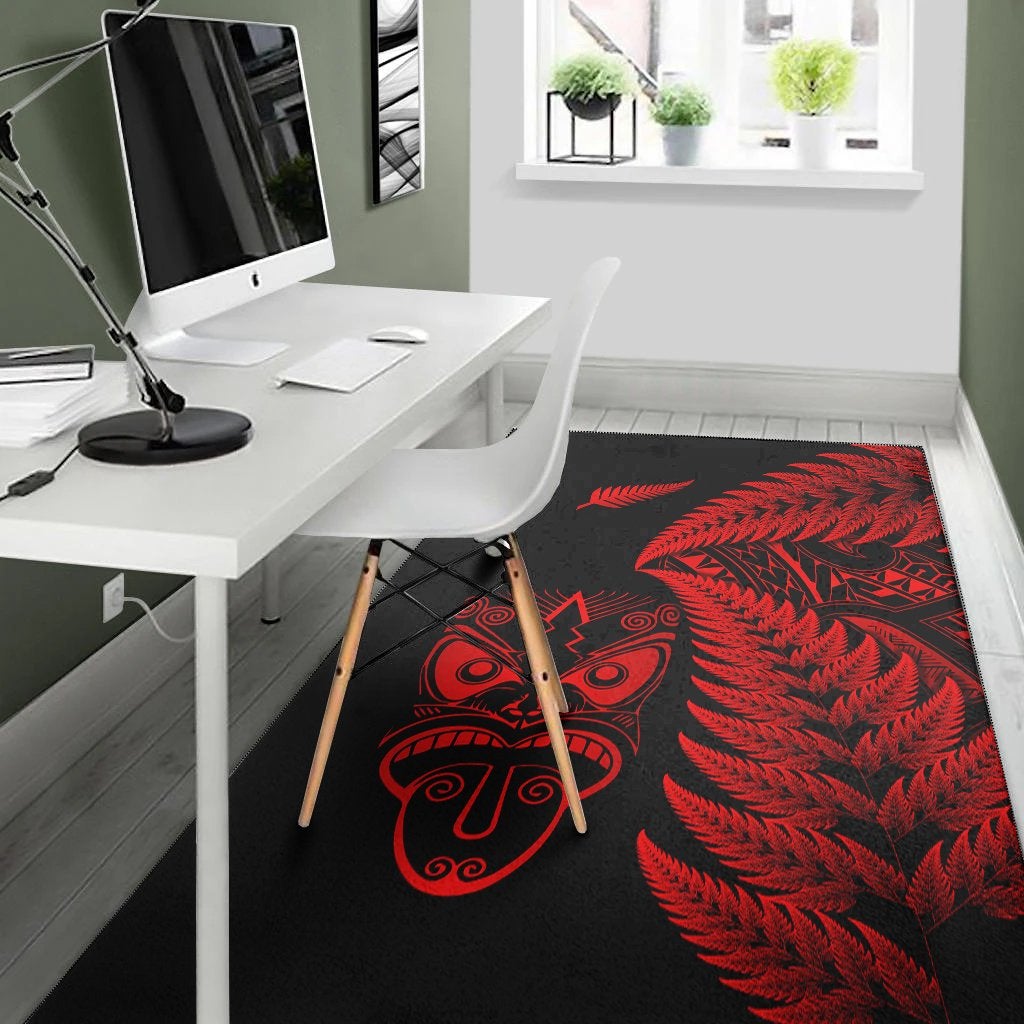 Black rug with red fern pattern and tiki face emblem