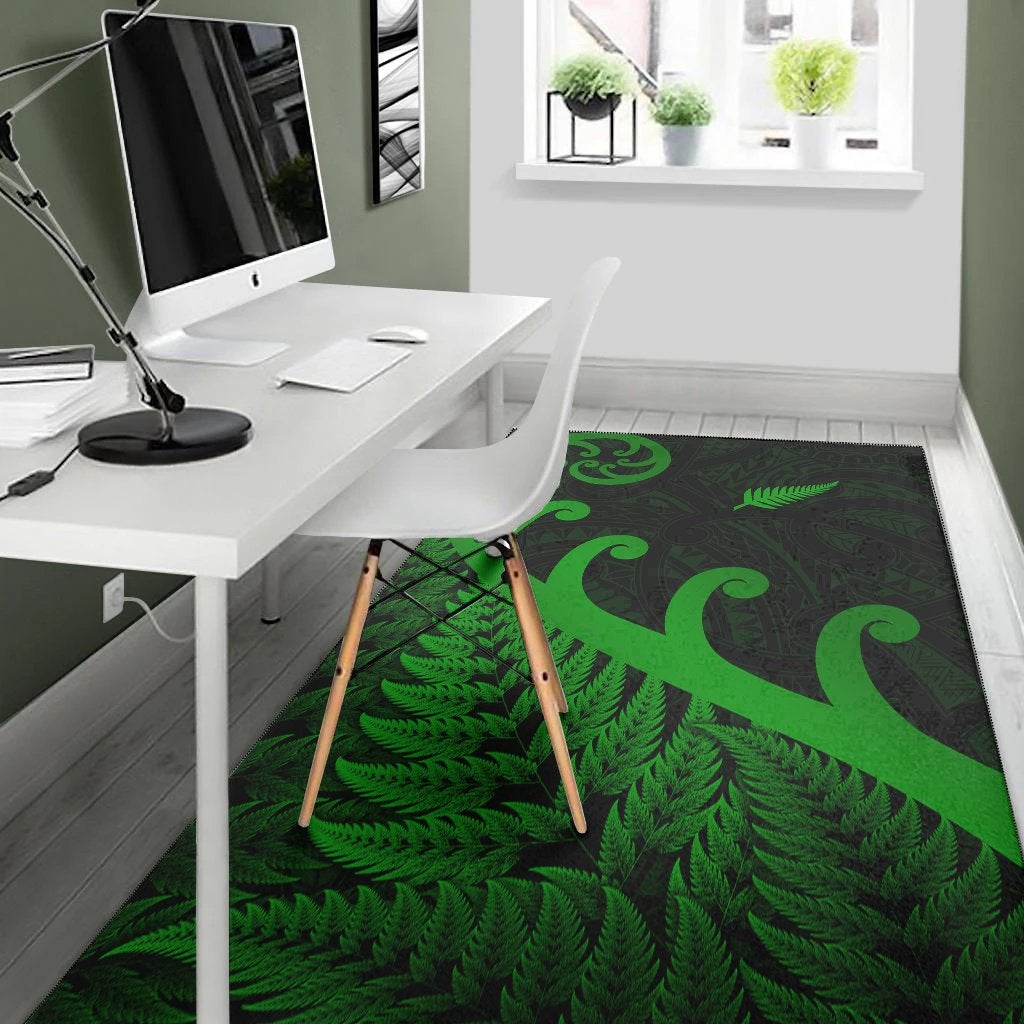 Green koru and fern leaf area rug on office floor; dark background with patterned center.