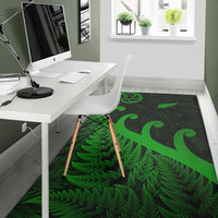 Green koru and fern leaf area rug on office floor; dark background with patterned center.