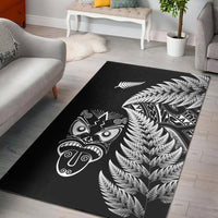 Black area rug with white silver fern and Maori-style face masks design