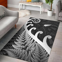 Black rug with white fern and koru swirl motifs, scattered leaf pattern