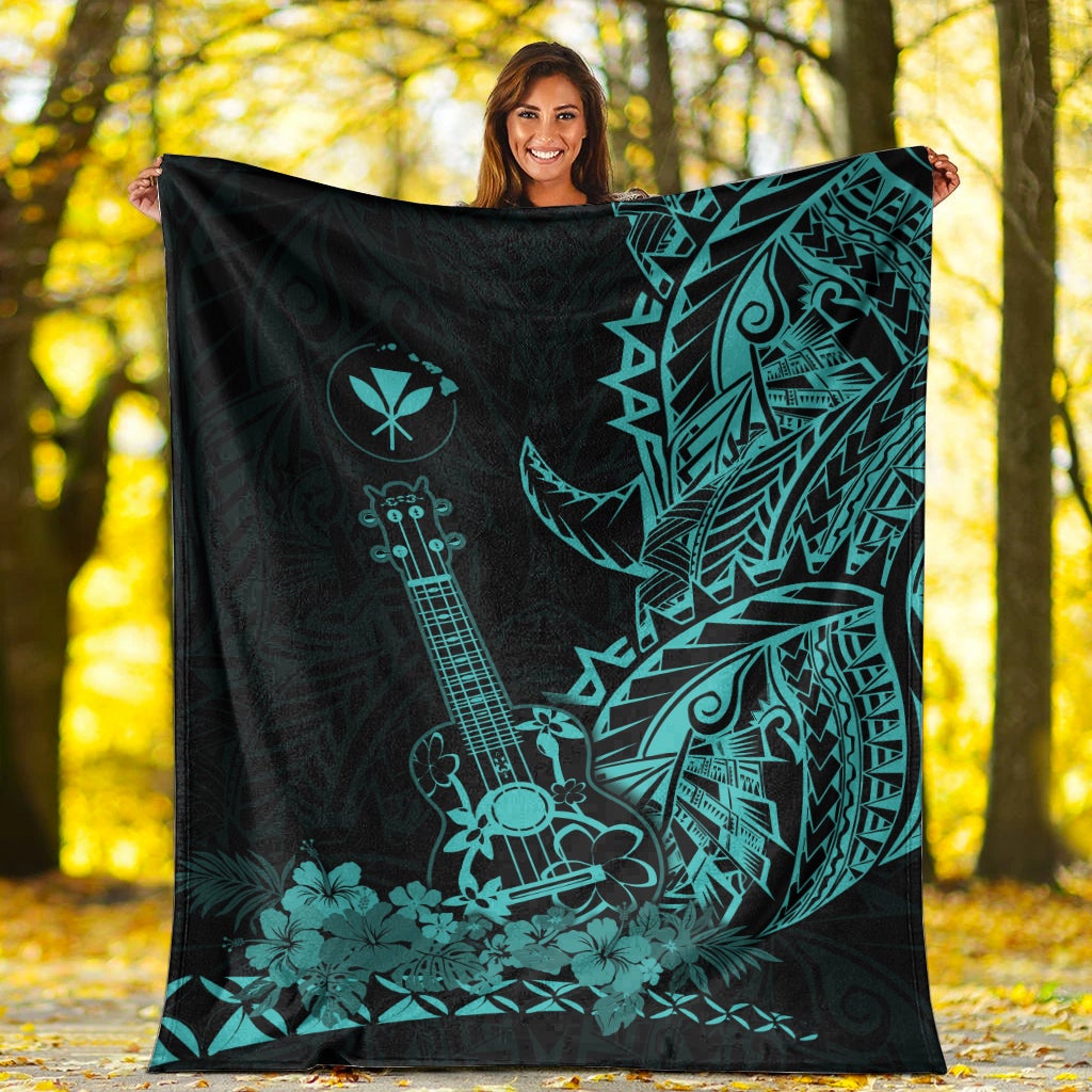 Black Hawaiian blanket with large turquoise ukulele, leaf and tiki motifs, spread out