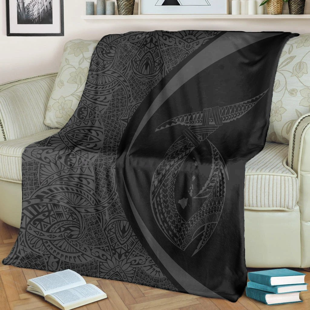 Gray & black Polynesian circle blanket with white border, spread over sofa