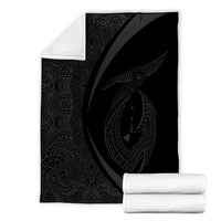 Folded gray & black Polynesian circle blanket with white border and rolled edge