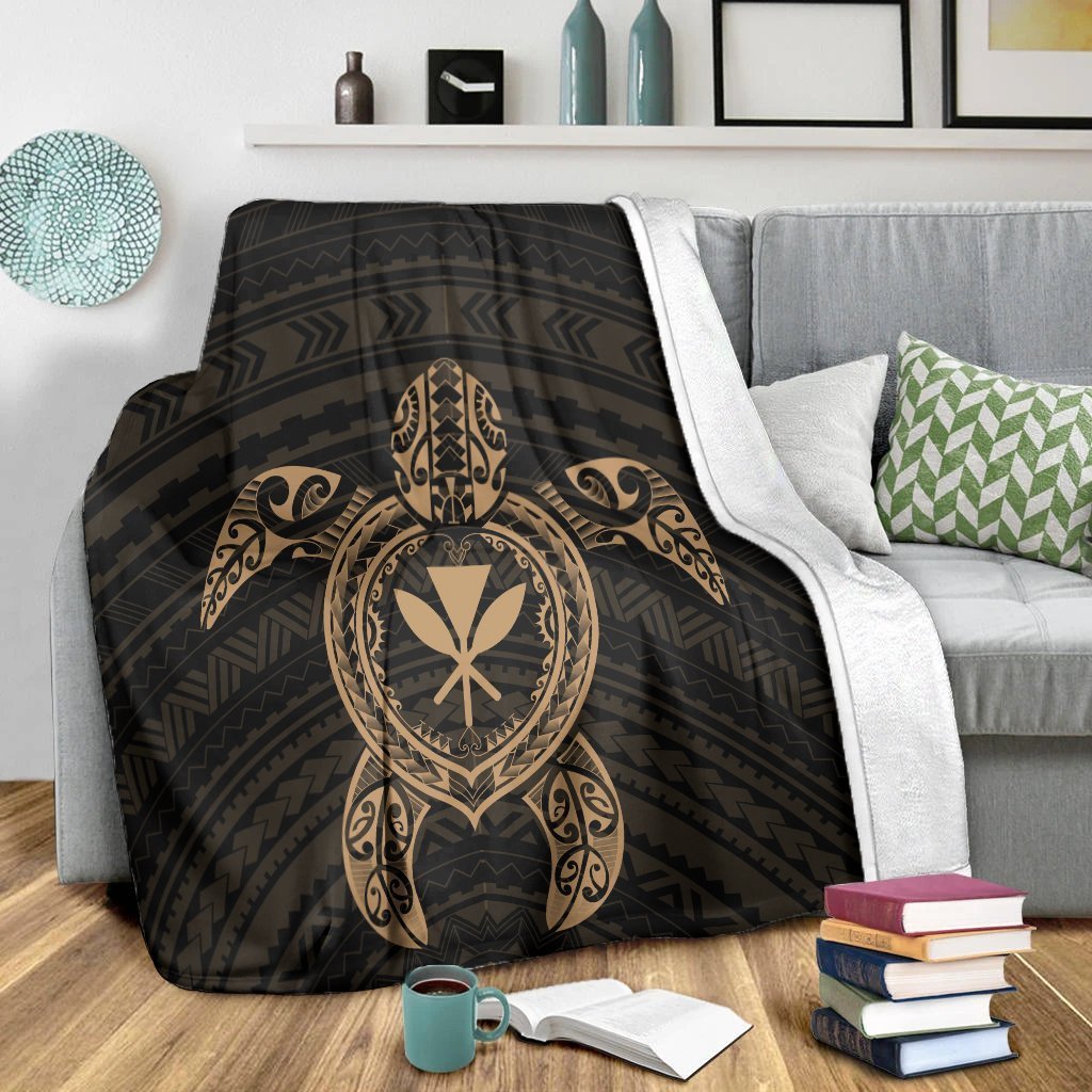 Black turtle motif blanket with gold heart emblem and Polynesian swirls on sofa