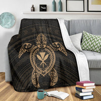 Black turtle motif blanket with gold heart emblem and Polynesian swirls on sofa