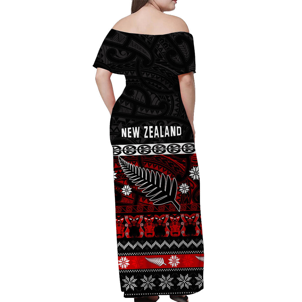 Off-shoulder long dress, back view in black with red and white Maori fern print