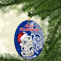 Blue oval ceramic Christmas ornament with Hei Tiki face and “Meri Kirihimete” text