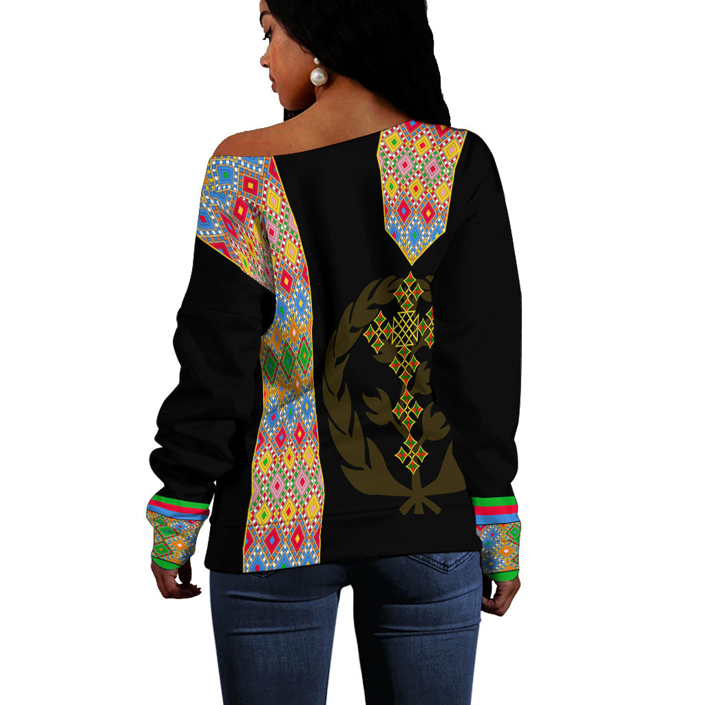 Black off-shoulder sweater back view with colorful geometric paneling and gold emblem