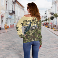 Women’s off-shoulder camo sweater with “REACH FOR THE SKY” plane graphic