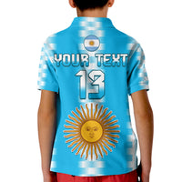 Kids light blue polo shirt with YOUR TEXT 13 and sun emblem, flag circle