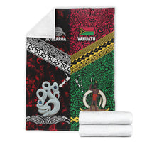Folded Aotearoa and Vanuatu patterned blanket set with two rolled white towels
