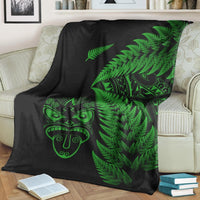 Black throw blanket with large green fern pattern and Maori face graphic